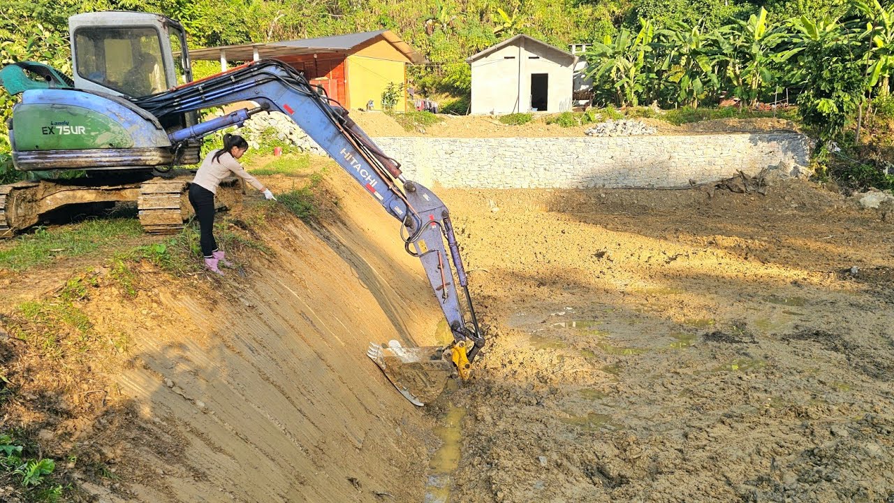The girl and the excavator completely cleared the giant pond./ Ban Thi Diet