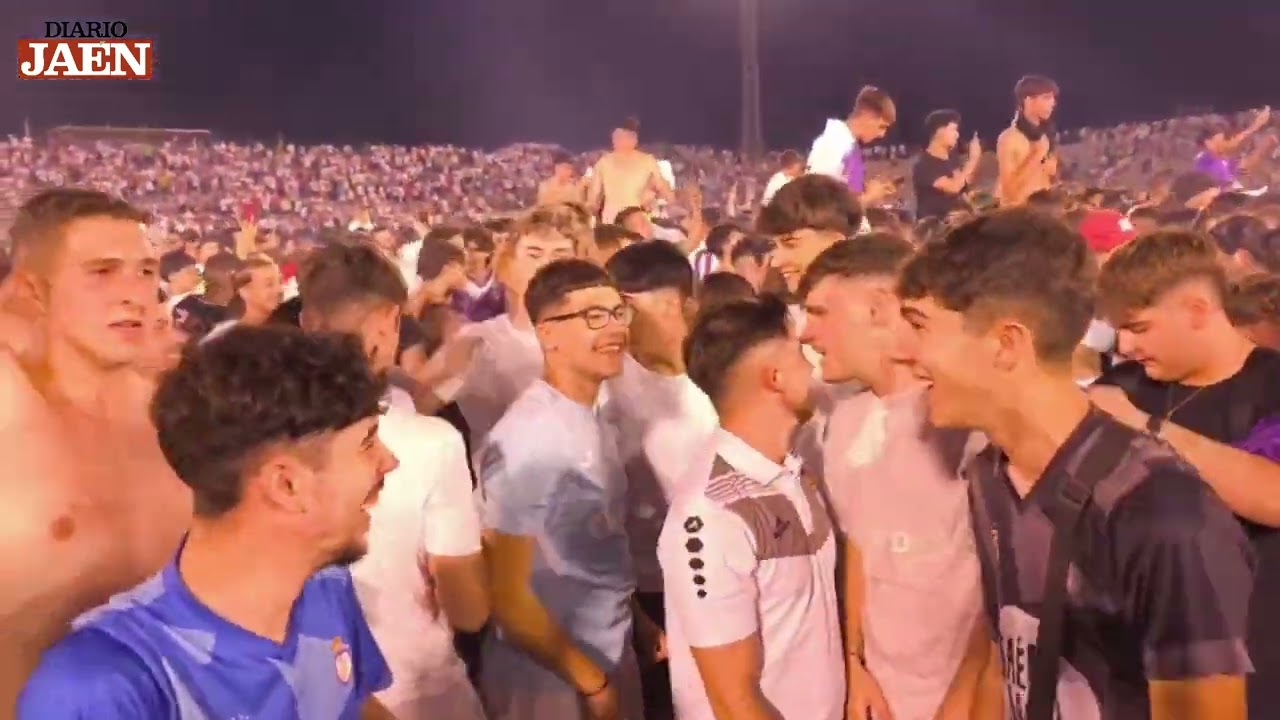 Jugadores y aficionados del Real Jaén celebran el ascenso en el campo de La Victoria
