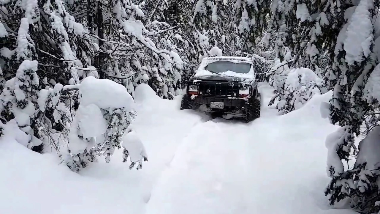 Jeep XJ on 33's in Fresh snow, braking trail, living every minute of it.