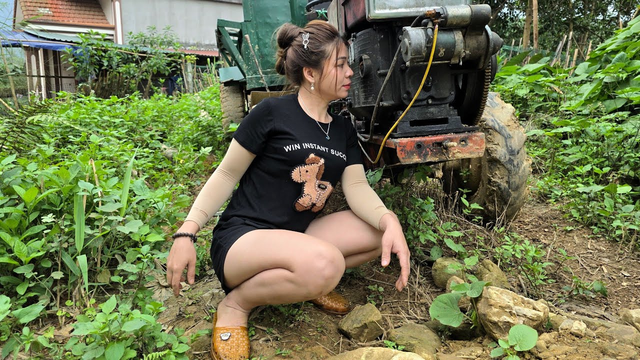 The talented girl has found the reason why the tractor's wheels won't start.