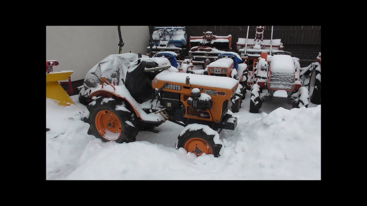 Traktorek Kubota B7001 przebija się przez zaspę śnieżną.