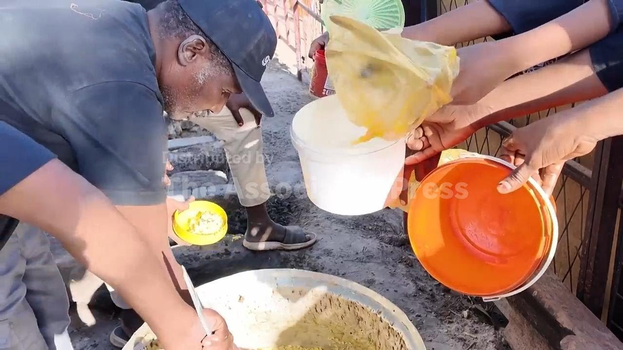 Muslims in war-torn Sudan pick up iftar meals from a charity kitchen during Ramadan