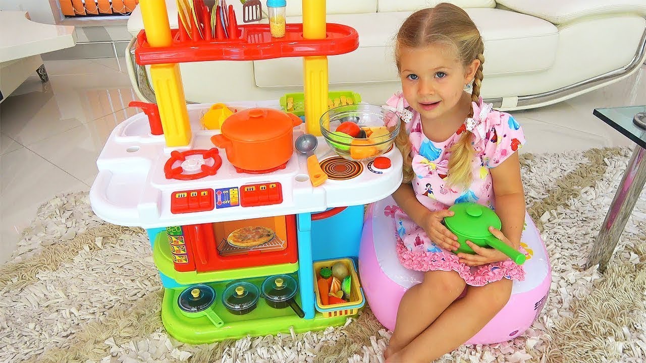 Diana e Roma fingem brincar com brinquedos de cozinha