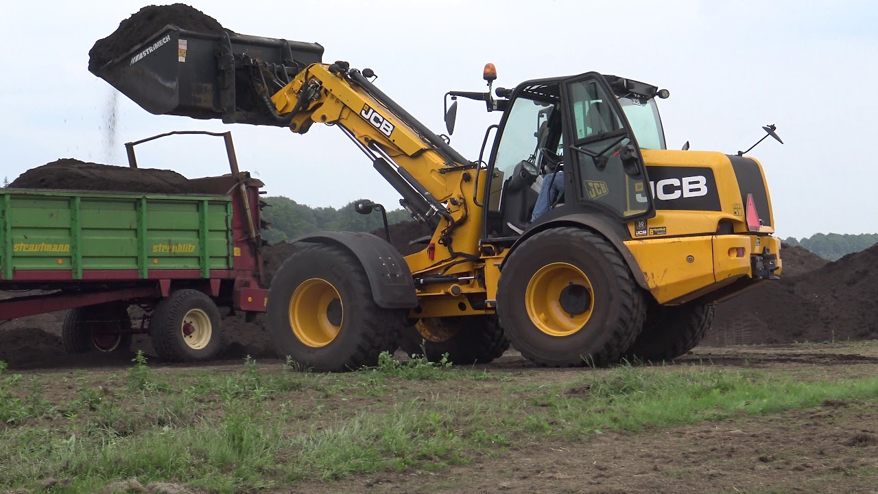 compost strooien met een neuw holland  T 7 .220 JCB