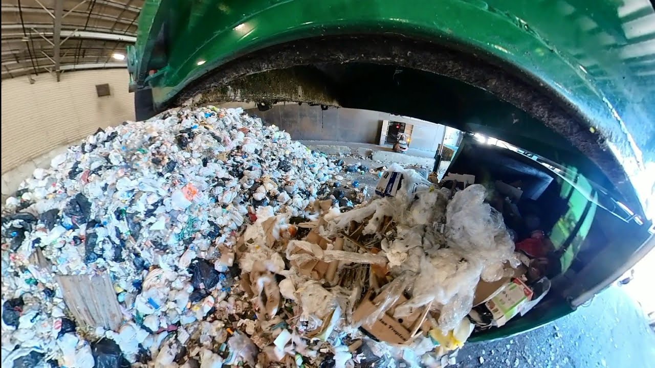 Waste Management garbage trucks dumping at transfer station.