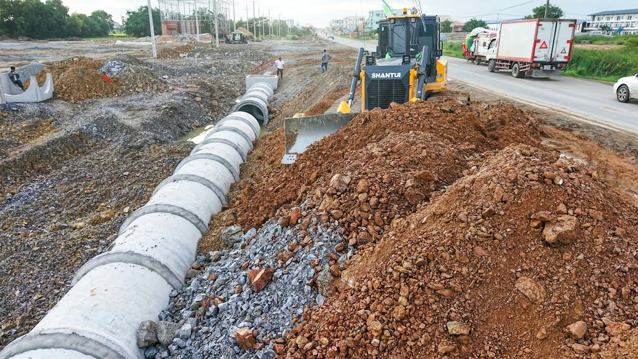 Powerful skill Shantui c3 pro dozer pushing stone bury drainage system with dump truck transport 