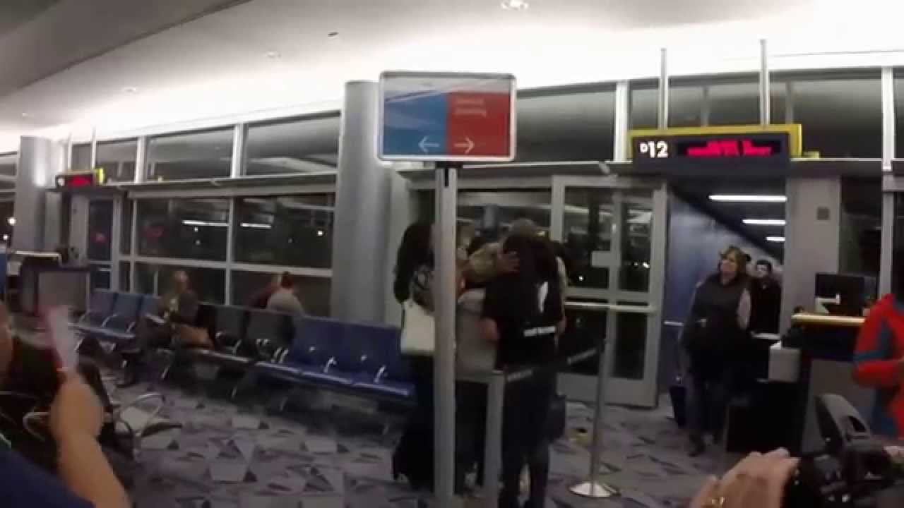 Soldier returns home from Afghanistan. Famiy and strangers greet him with cheers and aplause.