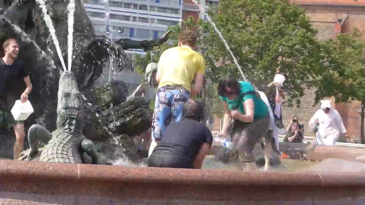 Hier hat Mann und Frau viel Spaß im Neptunbrunnen Berlin Mitte