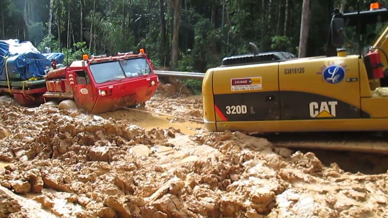Oshkosh 8x8 and Cat excavator going thru heavy mud