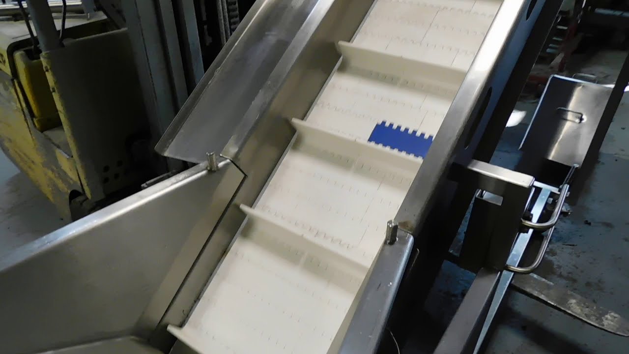 Inclined cleated conveyor