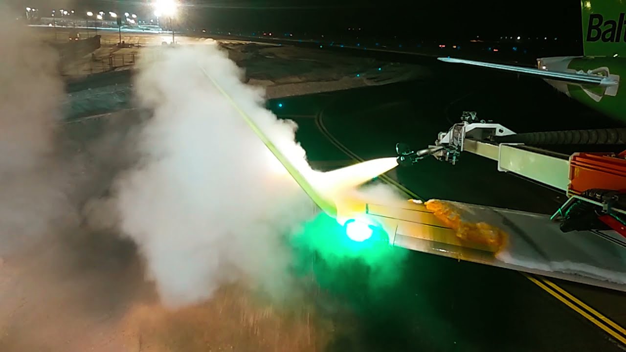 Airbus A220 covered with snow and ice. Deicing procedure at Riga.