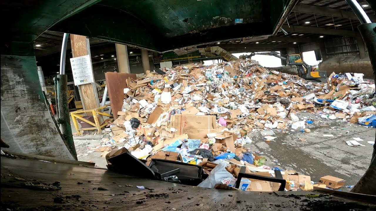 Garbage truck ejecting loads and quick clean behind the blade. Heil freedom halfpack truck