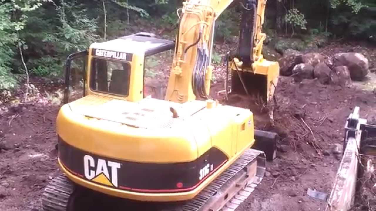 Cat 311 grubbing out and loading a 10 wheel dumper