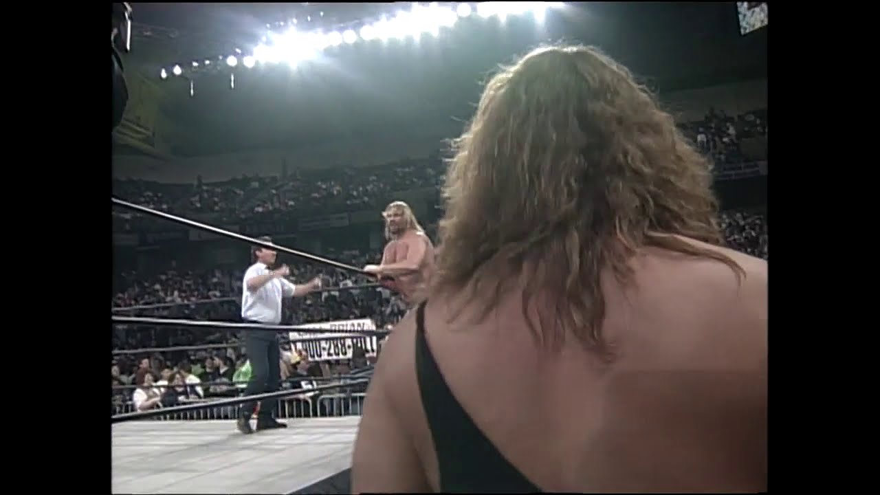 Brian Pillman tries to jump the guard rail at ringside and gets dragged away by Security! (WCW)