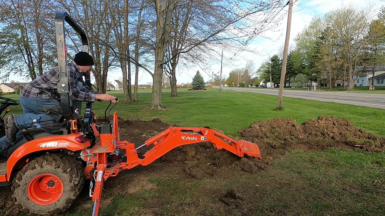 Installing a drain pipe using Kubota BX23S Backhoe