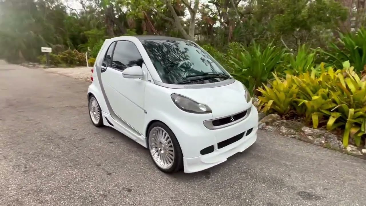 Smart car featuring gull wing doors, custom wheels and body upgrades.