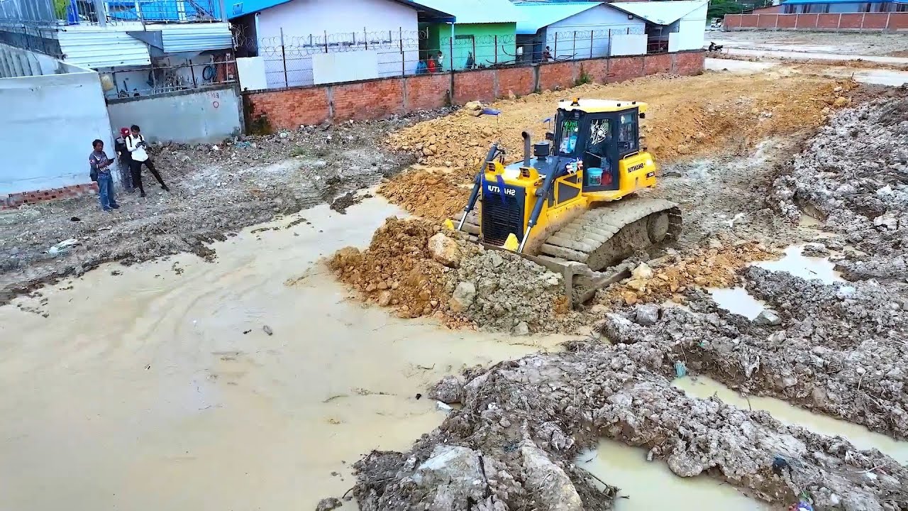 Heavy Equipment Earthmoving: Powerful Bulldozer Shantui Pushing Dirt into Waterway Channel