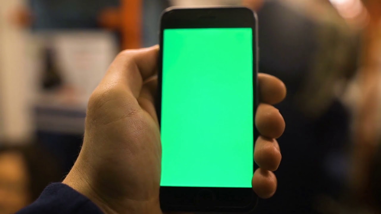 4k close up of hand holding a smartphone with green screen display at underground train station shot