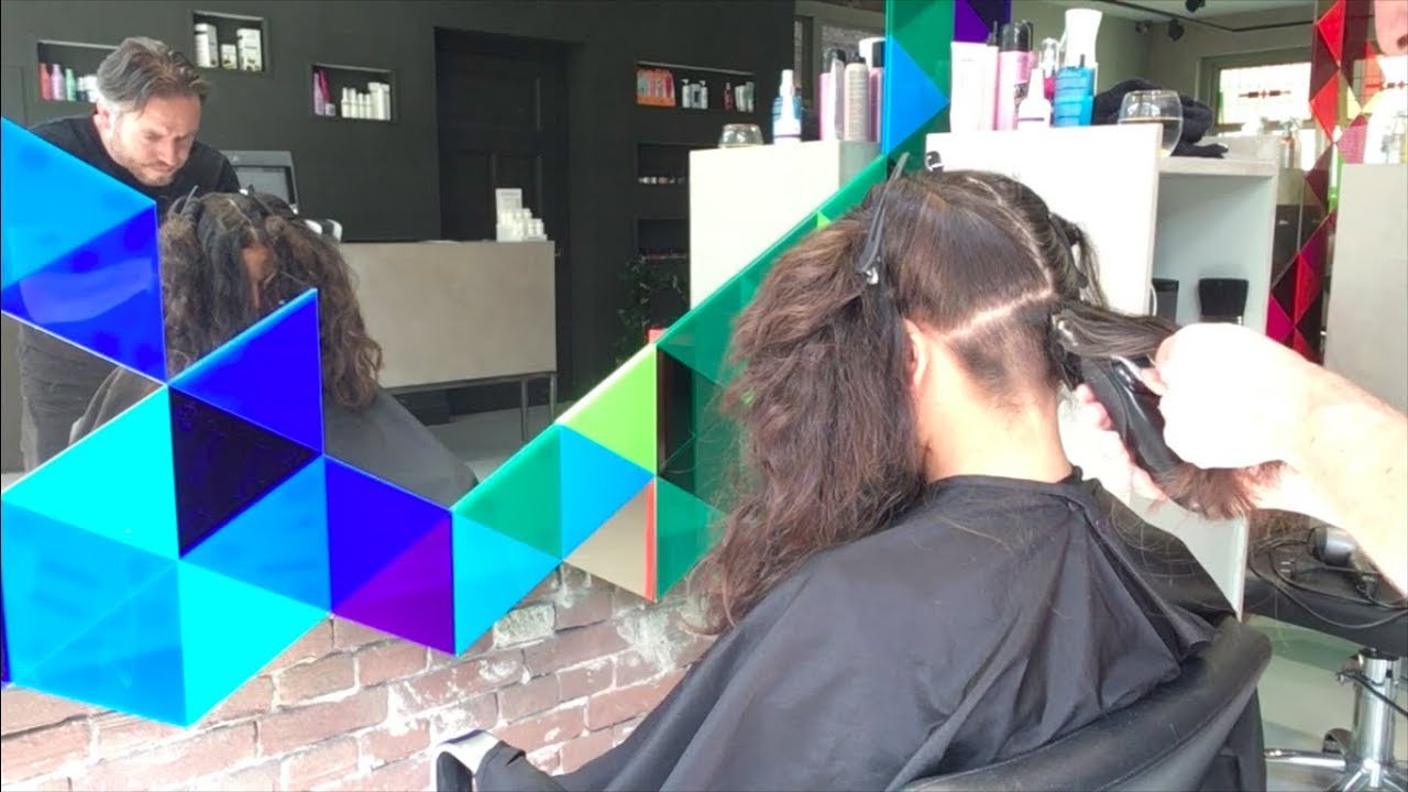 A layered haircut on curly hair with an undercut