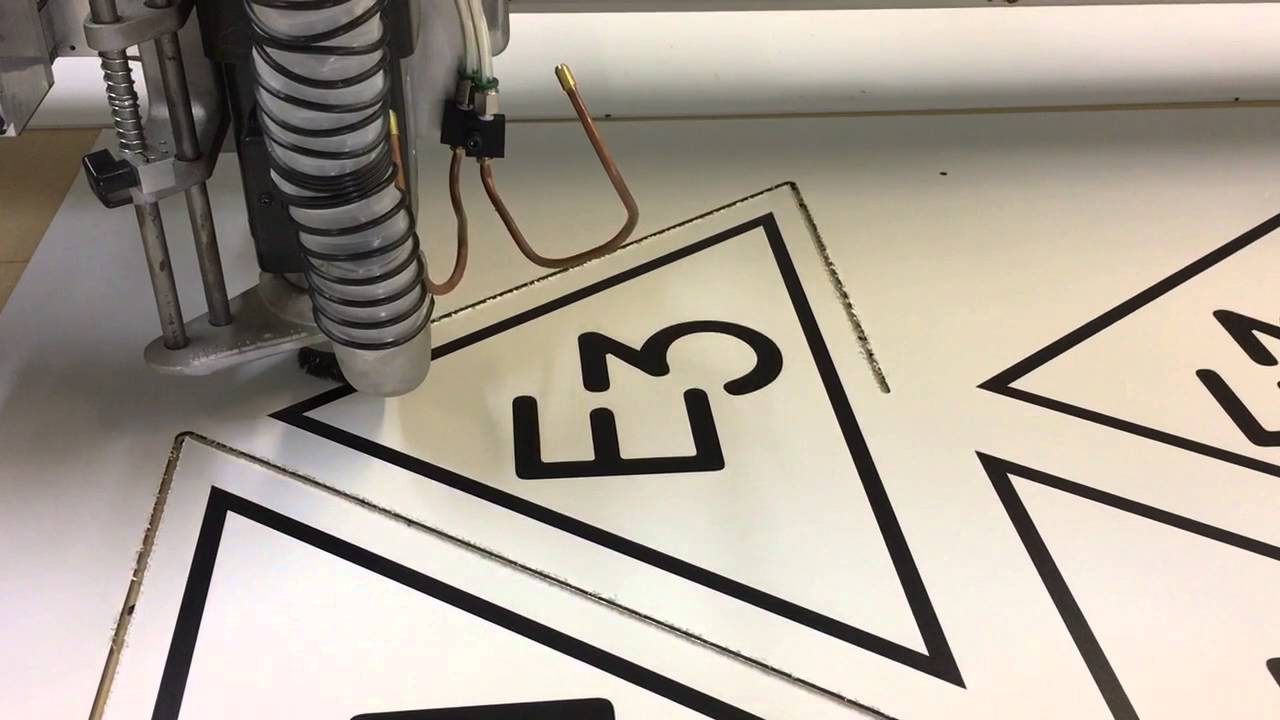 Signs being router cut out of aluminum composite on a Multicam 3000