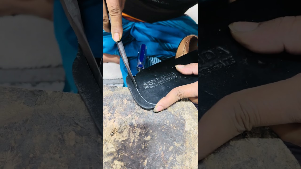 Large leather shoes being cut to size by hand 