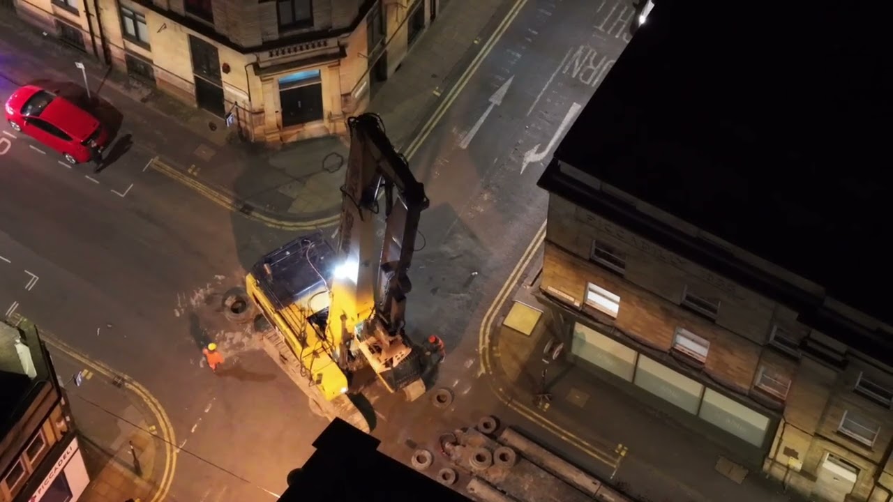 DJI Air3S Drone Video Police escort Caterpillar 345 Long reach demolition excavator through Bradford