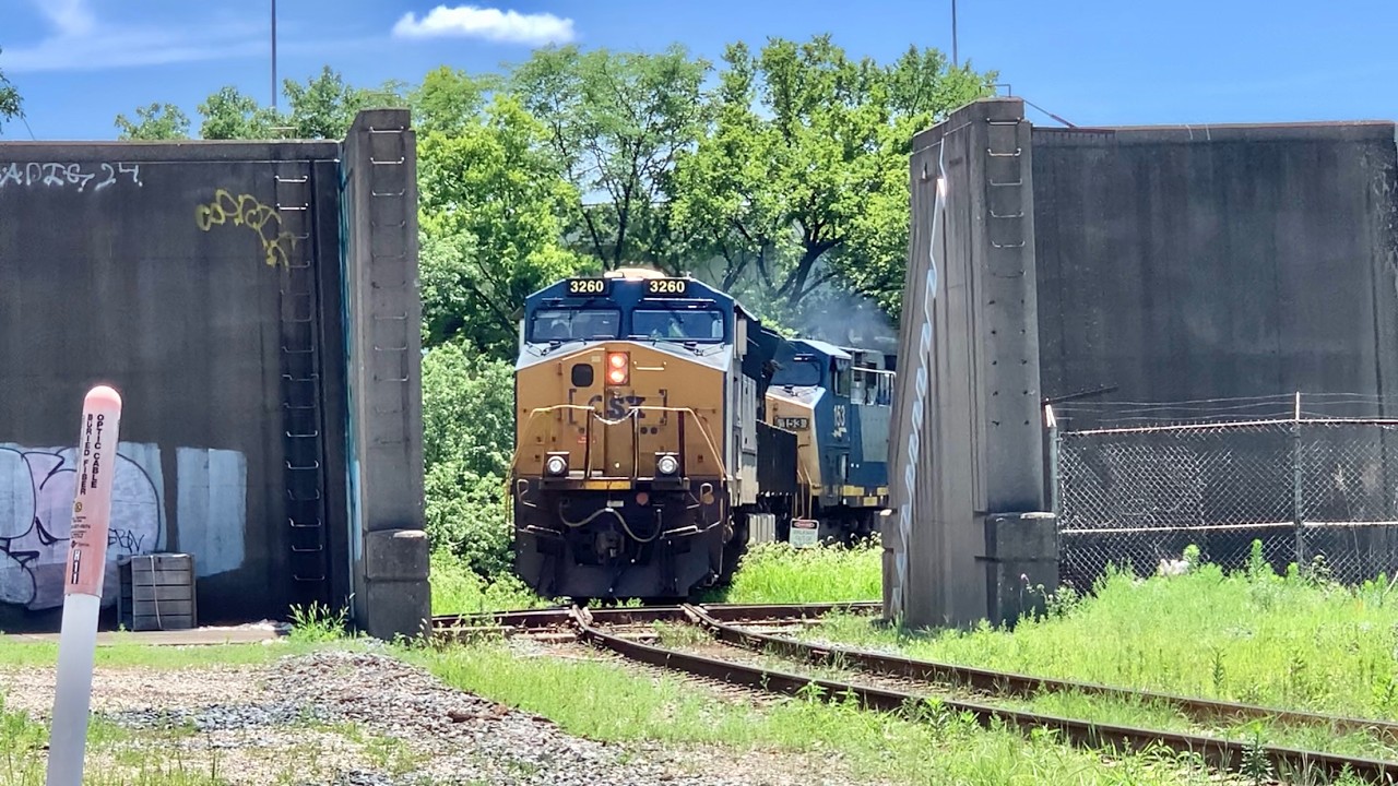 Trains Cross RR Diamond & Pass Thru Flood Wall!  Train & Truck Meet On Giant Bridge Over RR Yard