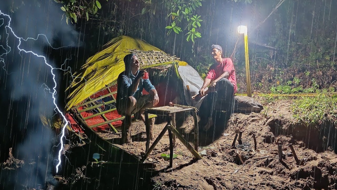camping hujan deras di pinggir sungai membangun rumah di bawah kayu tumbang tidur pun nyenyak