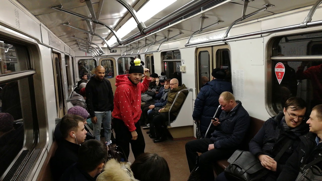 Парни танцуют в вагоне метро.