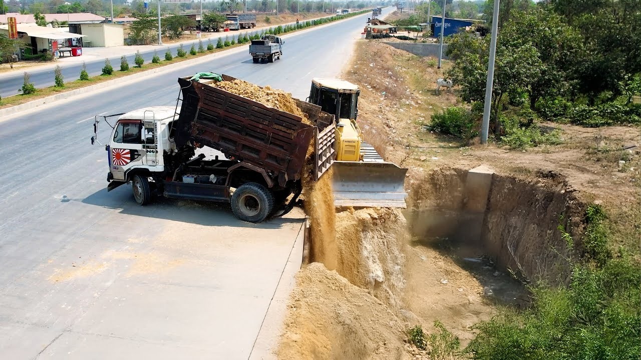 Start of the operator by Dozer KOMATSU DR-51px Pushing Soil with Dump Trucks 5 tons
