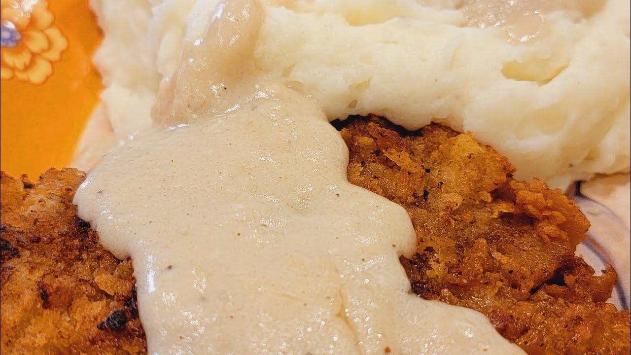 Жареный стейк из курицы, белый деревенский соус, картофельное пюре и приготовленные на скорую рук...