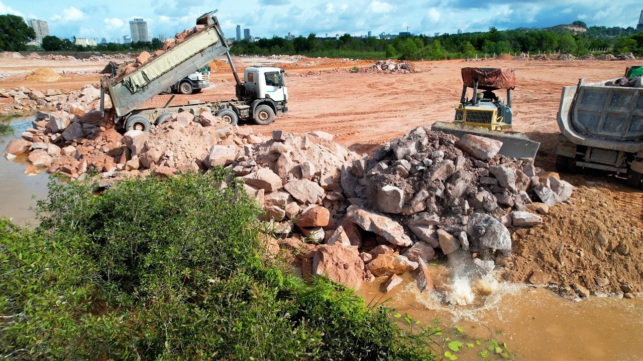 Skillful Heavy Equipment Operator Bulldozer Pushing Rock Stone Drop Into Water For Land Reclamation
