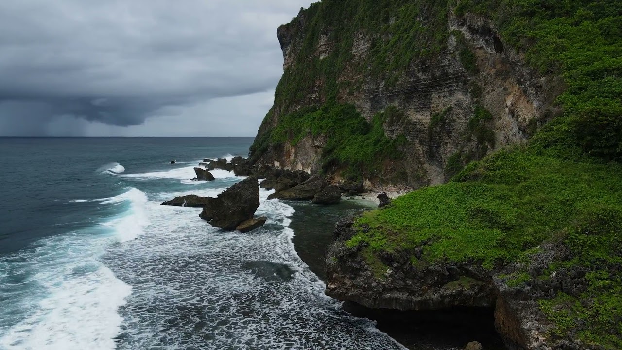Stormy Weather in a Moody Island surrounded with hills and ocean weave. Island Video 4k(Aerial view)