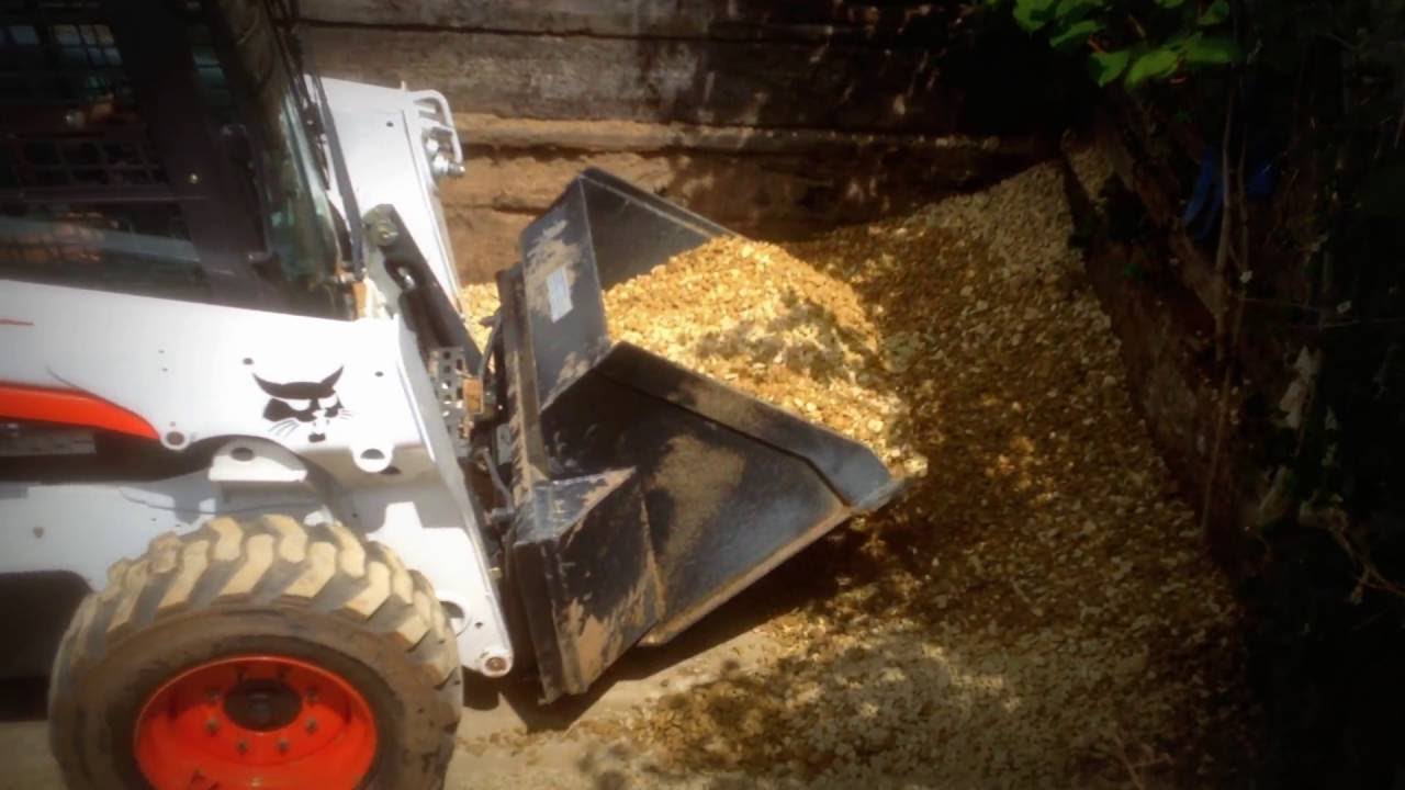 Bobcat with builders bag filling bucket by Evans & Reid