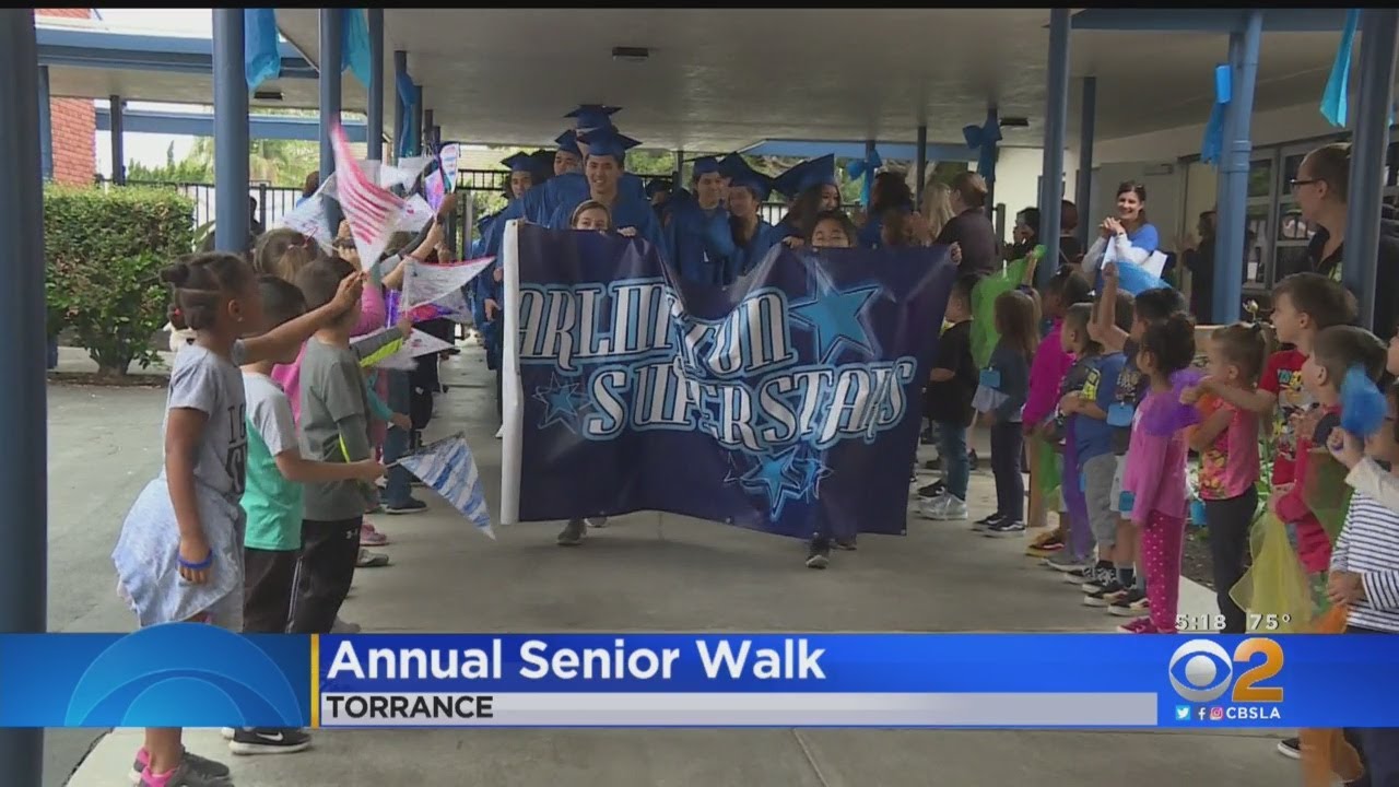 High School Seniors Walk Their Former Elementary School In Caps And Gowns