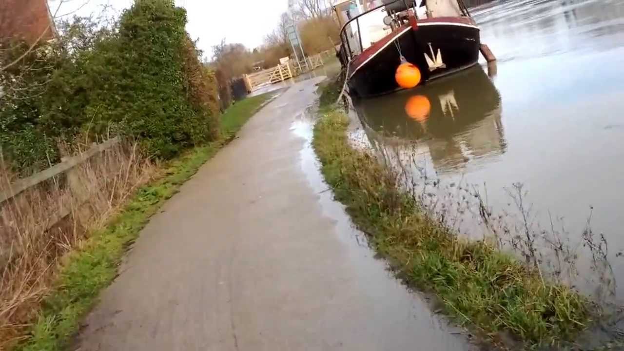 Cycling along flooded towpath on Thames/Isis near Iffley Lock, Oxford