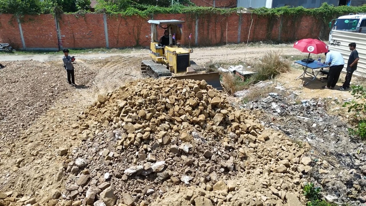 start! Powerful land filling action with dump trucks and Komatsu machines moving stone and soil.