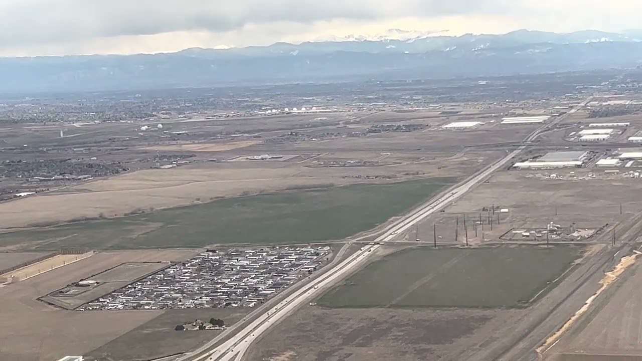 Cold April Denver, Colorado landing / arrival aerial views (Rockies, downtown Denver)