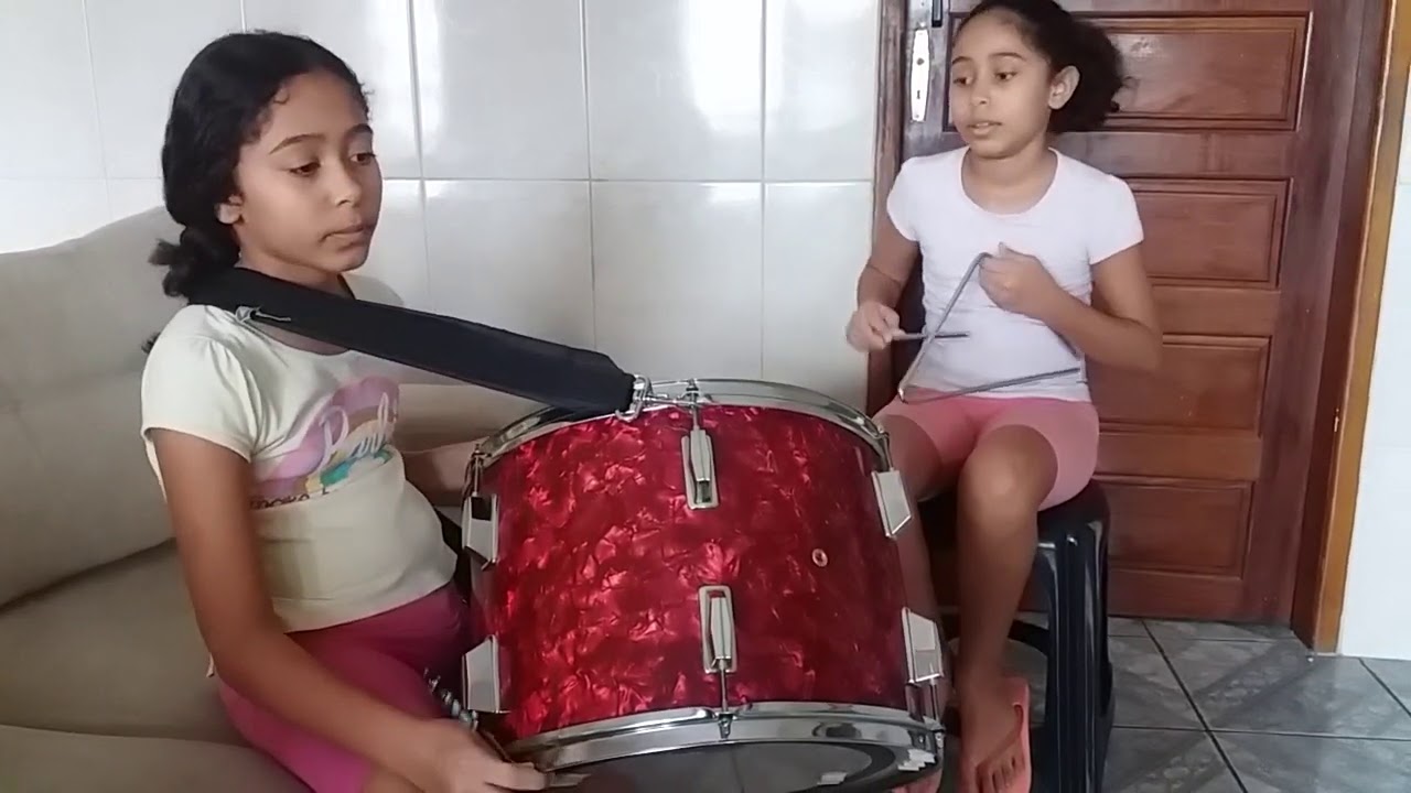 Desafio dos ritmos com crianças de 10 anos tocando triângulo e zabumba.