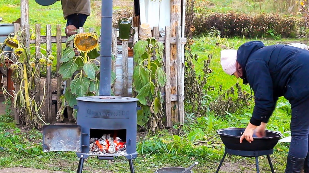 Happy family builds a house far from civilization. Cooking Uzbek pilaf on an outdoor stove