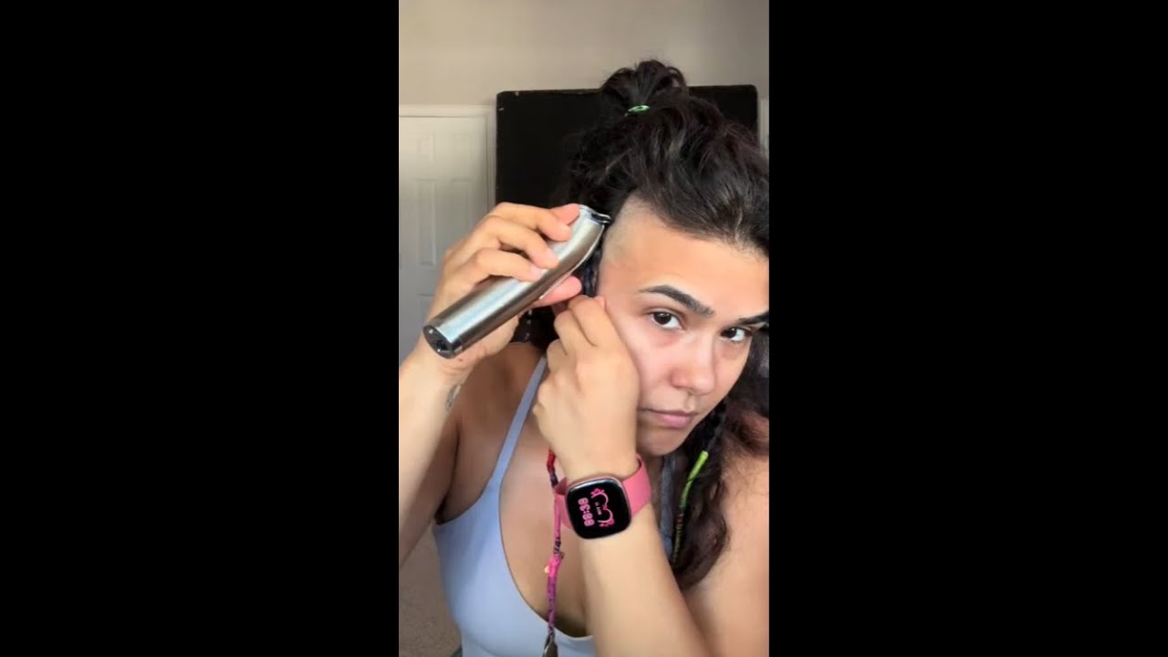 Gorgeous woman buzzes off her long brown hair in her bedroom