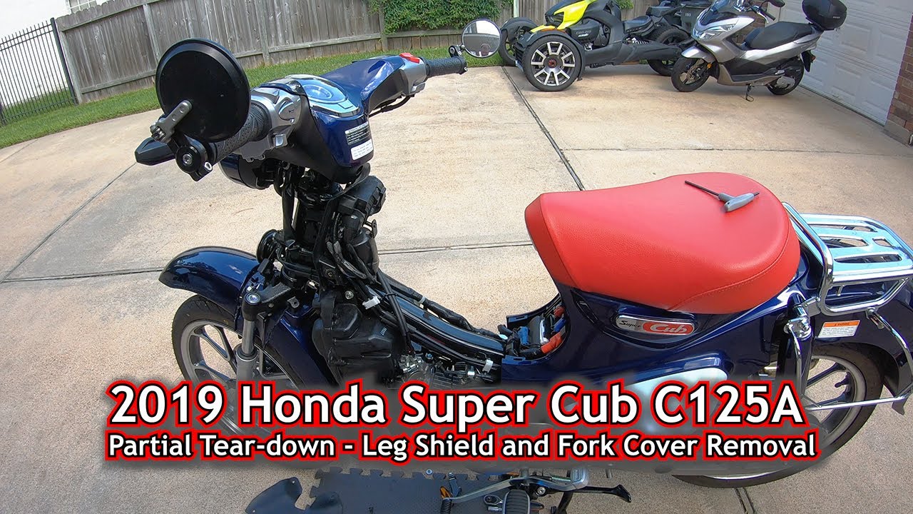Honda Super Cub C125 2019 года: снятие защиты ног и крышки вилки