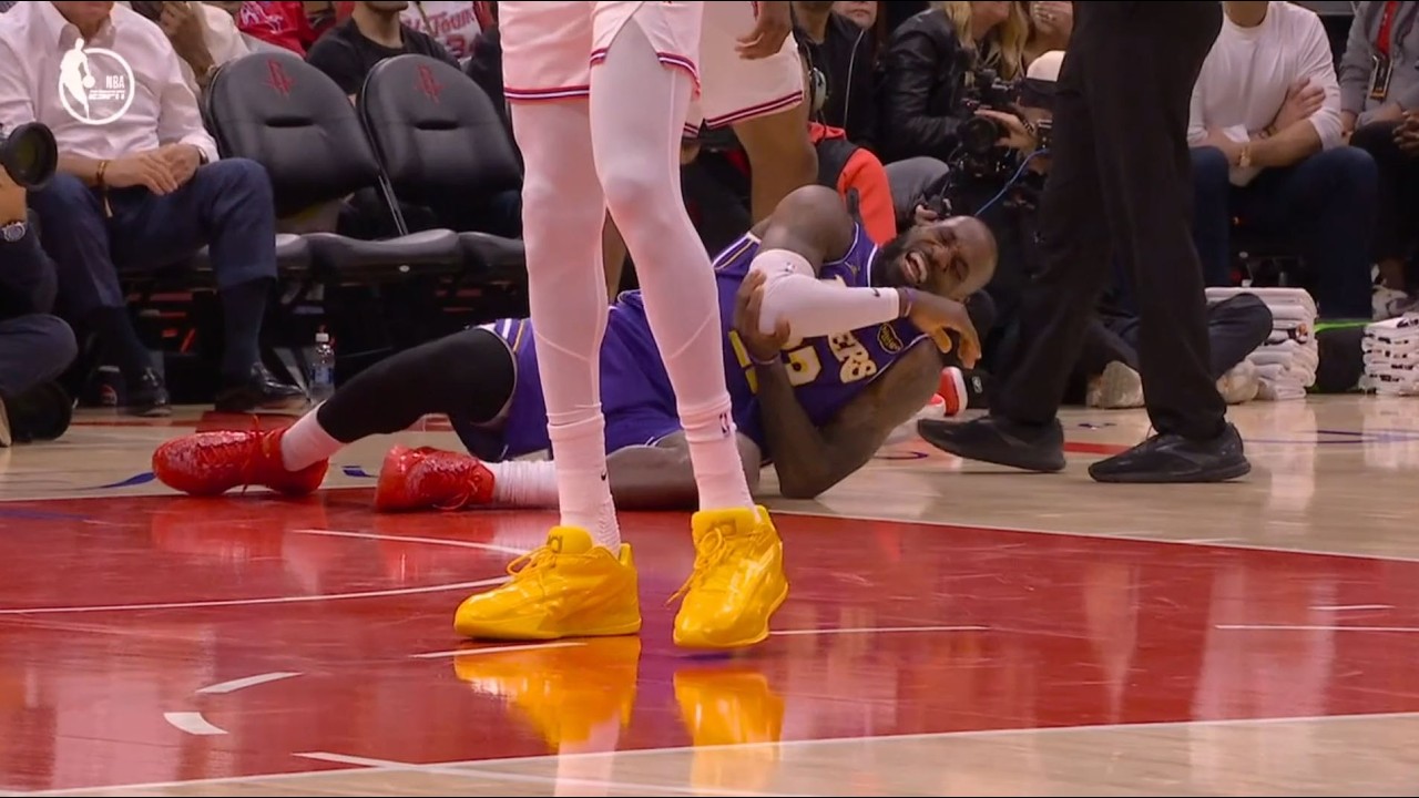 LeBron James holds his right arm and wrist in pain after a chasedown block attempt by Jabari Smith