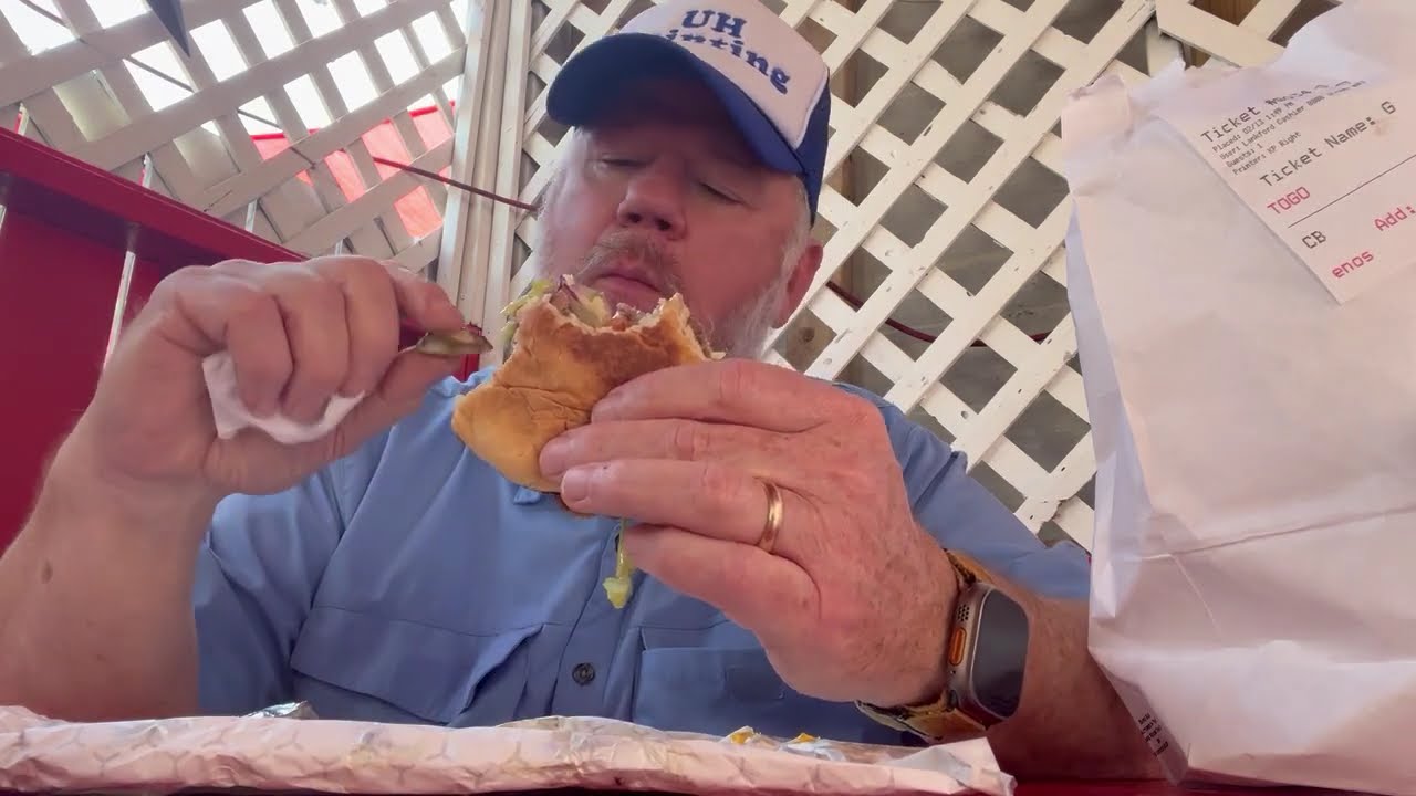 Samueliteaux eats a cheeseburger with jalapeños at Lankford Grocery, 2026.