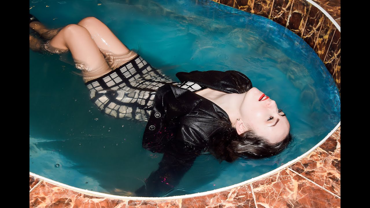 beautiful girl after work in office in wet clothes in swimming pool posing for wetlook video