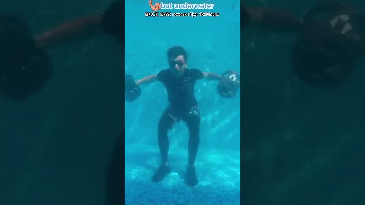 Professional Swimmer Does Weight Lifting Exercises Underwater in Pool-1334625