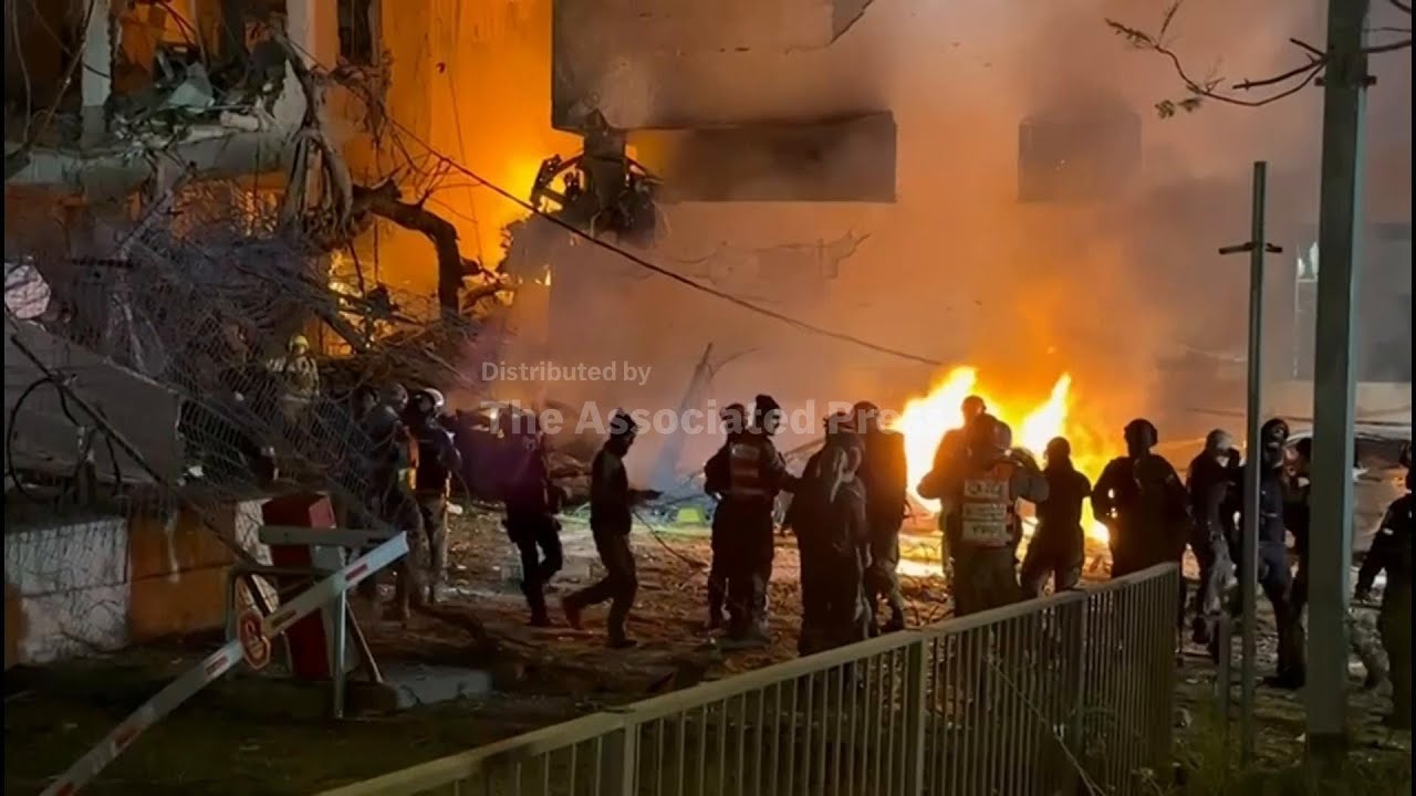 Cars on fire as Israeli emergency services respond to projectile hit amid Iran retaliation