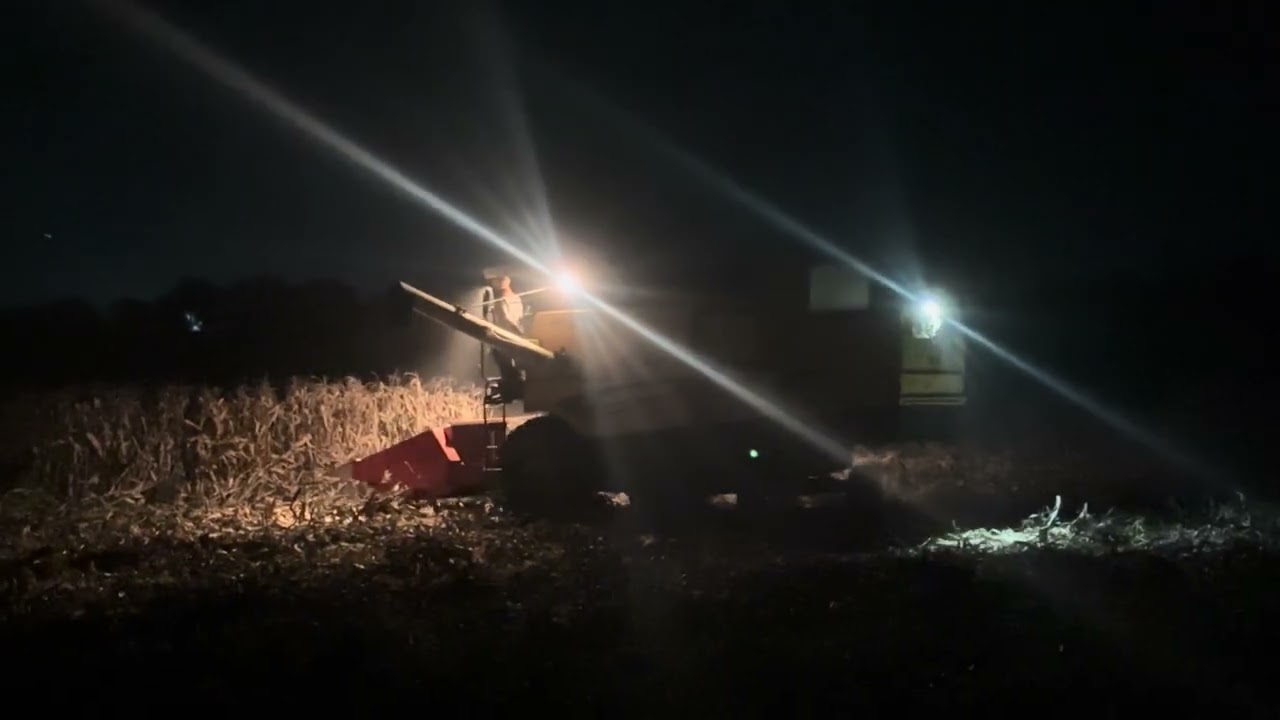 New holland harvester working in night field 