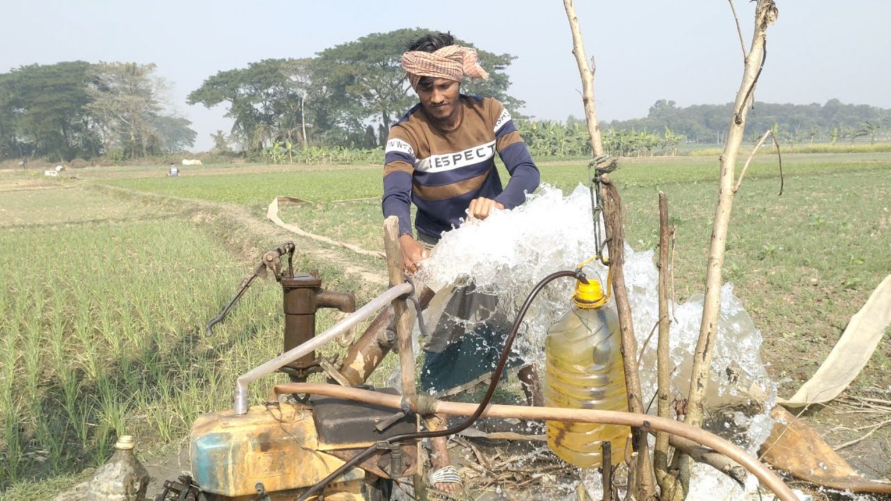 Video of the village boy watering the land with a pipe after giving the shallow machine