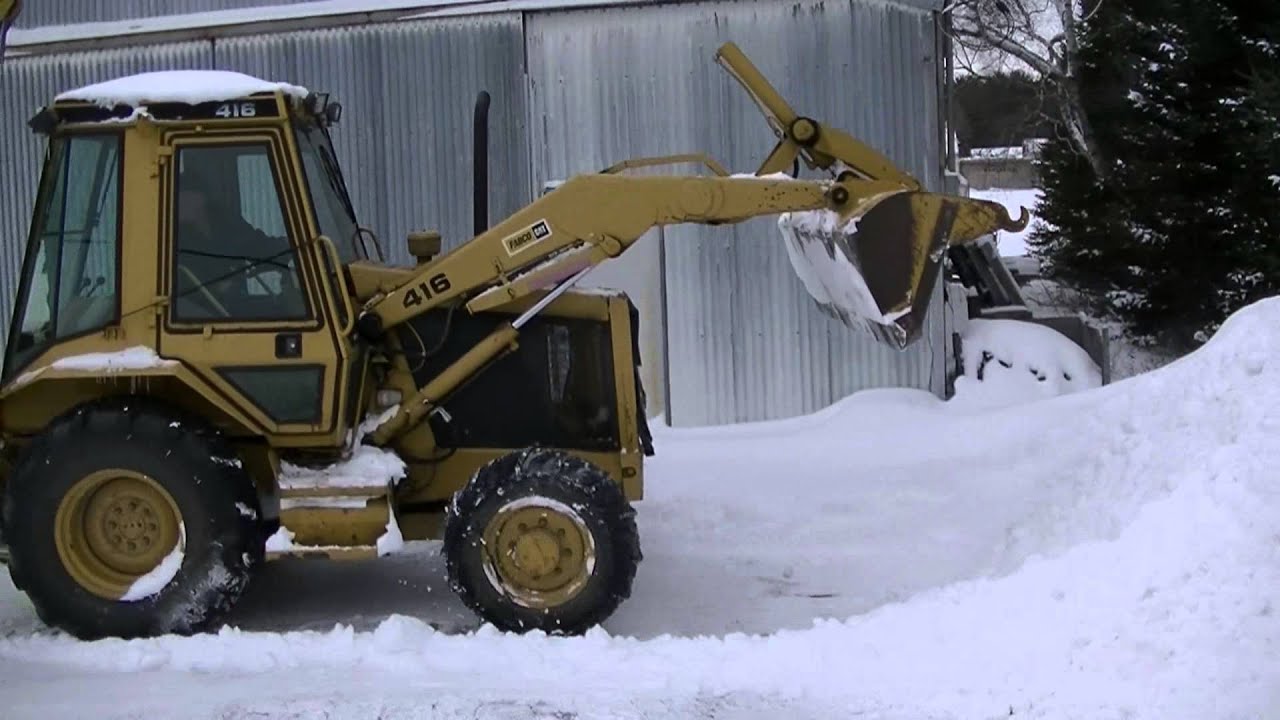 CAT 416 Backhoe Stacking and Pushing Snow
